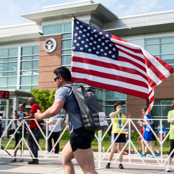 Man running with American flag in front of LifeNet Health